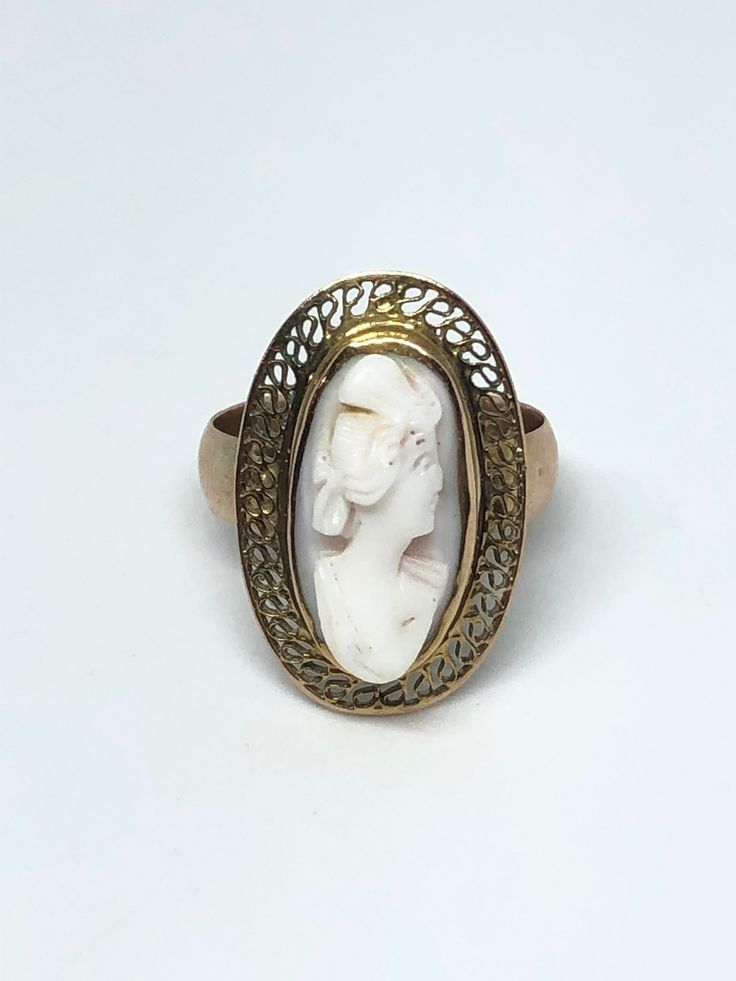 1930's Antique 10K Cameo Ring Size: 3.5 Weight: 3.10 grams 𖧷 Hand-carved Natural Coral Cameo 𖧷 Solid 10K Yellow Gold (Tested) 𖧷 Classic Vintage Design with Filigree Detail This Lovely Cameo Ring is an awesome antique piece of jewelry that must hold a lot of history. The carving is likely of a Mother or Grandmother that was gifted to a daughter. It is estimated to be from the 30's but could possibly date all the way back to the Victorian Era. As this is an authentic antique item it shows some Vintage 14k Gold Cameo Rings, Vintage Yellow Gold Cameo Rings, Art Deco Cameo Ring For Collectors, Art Deco Cameo Ring Collectible, Art Deco Cameo Collectible Rings, Antique Cameo Ring Collectible, Ornate 14k Gold Collectible Ring, Art Deco Oval Cameo Rings, Heirloom Carved Engraved Ring For Collectors