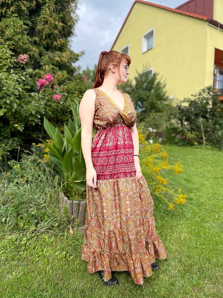 Our summer boho maxi dress is made of silk blend with beautiful floral print. It is a perfect attire for summer evenings and days. The skirt is wide and made from 5 parts stitched together with a decorative stitching. It is made with a natural 70% silk fabric in perfect hippie boho chic style. A perfect attire for a real flower child! The best choice to impress, you'll look divinely beautiful in this chic boho dress with slightly oriental flare.  SIZE  Chest 102 cm Waist 92 cm The dress is suitable for breast up to EU size 5. Length is 139 cm.  The material is 70% silk, 30% viscose. This piece is handmade in Kashmir. Hippie Boho Dress With Floral Print For Garden Party, Hippie Floral Print V-neck Maxi Dress, Bohemian Sleeveless Sundress For Garden Party, Floor-length Boho Print Maxi Dress, Bohemian Floral Print Maxi Dress For Festivals, Floral Print Maxi Boho Dress For Festivals, Bohemian Maxi Dress With Floral Print For Festivals, Summer Boho Dress With Floral Print For Festival, Floral Print Maxi Dress For Festival