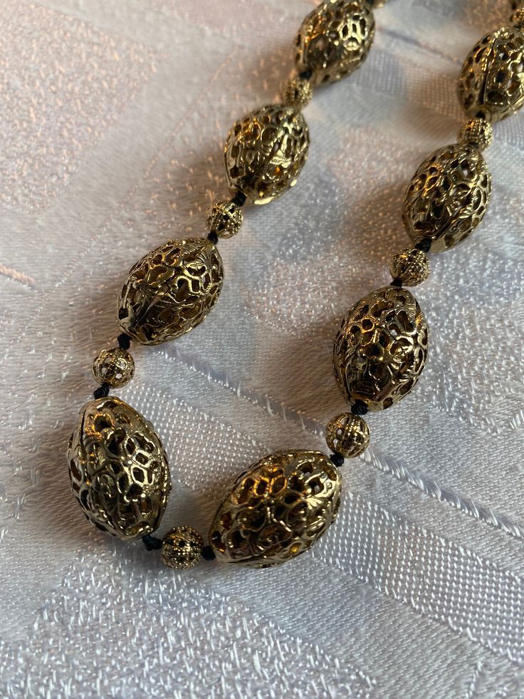 Vintage Monet gold tone filigree bead necklace  Quality piece, heavy and substantial  It measures 24 inches long inc the extender chain  In excellent condition, beads are knotted onto cord Oval beads approx 20 mm x 13 mm in size Gold Metal Necklace With Polished Beads, Gold Necklace With Polished Metal Beads, Antique Polished Gold Beads, Antique Large Gold Beads, Antique Gold Polished Beads, Gold Beaded Metal Necklace, Vintage Gold Polished Beads, Vintage Polished Gold Beads, Antique Gold Beaded Necklaces With Large Beads