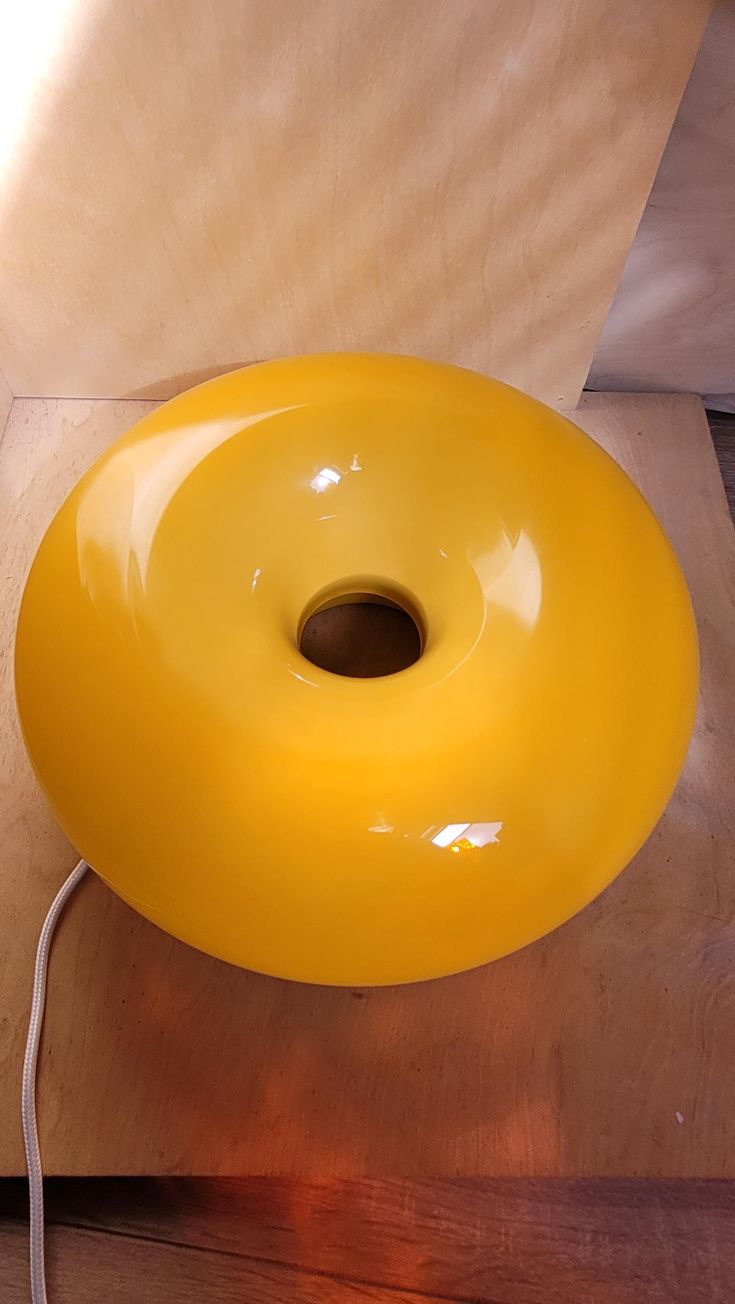 a large yellow object sitting on top of a wooden table next to a light bulb