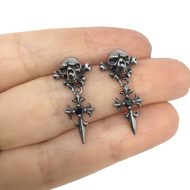 Artfully crafted Skull and Cross studs earrings are made of Stainless steel . Skull has 3-D look and it is hallow inside, which makes them pretty light. Those studs are gender neutral and perfect for men, women and kids. -Size is around 1 inch long from edge to edge -All items are shipped in a gift box Gothic Streetwear Jewelry, Gothic Silver Surgical Steel Earrings, Gothic Skull Jewelry For Biker Events, Gothic Metal Earrings For Streetwear, Gothic Pierced Jewelry For Streetwear, Gothic Surgical Steel Earrings As Gift, Gothic Cross Earrings For Pierced Ears, Gothic Skull Shaped Pierced Earrings, Gothic Skull Metal Earrings