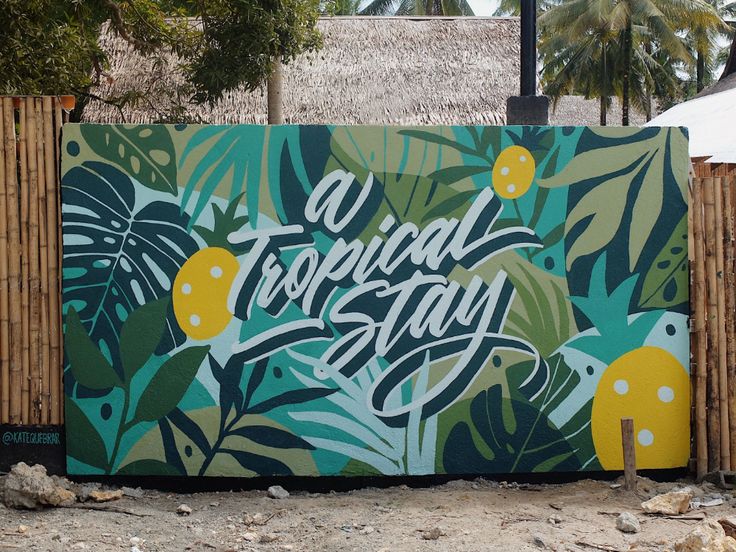 a mural painted on the side of a building with tropical leaves and lemons around it