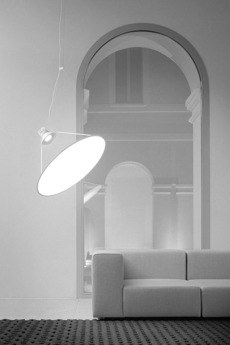 a white couch sitting under a light fixture