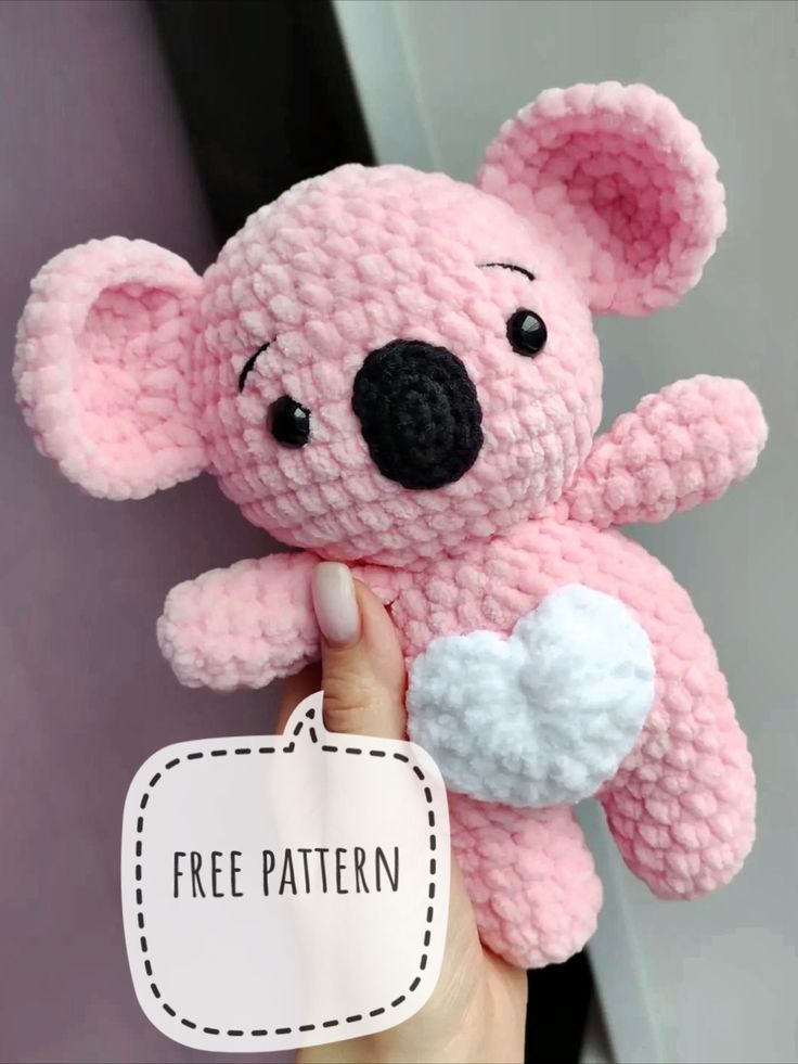 a pink crocheted koala bear holding a free pattern