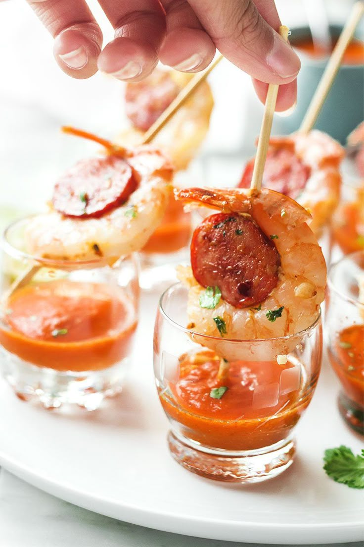 shrimp skewers with tomato sauce and parsley garnish on a white plate