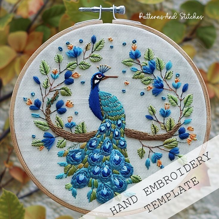 the embroidery pattern shows a peacock on a branch with blue flowers and leaves in it