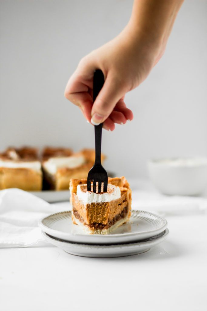 a person holding a fork over a piece of cake