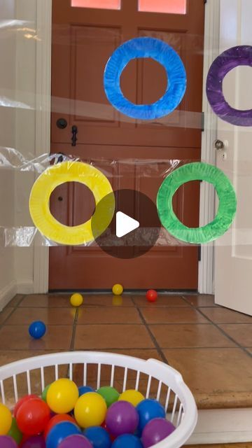 a basket full of balls sitting in front of a door with plastic rings hanging from it