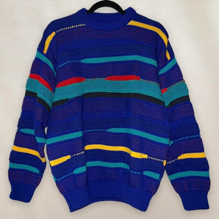 a blue sweater with multicolored stripes on the front and back, hanging from a hanger