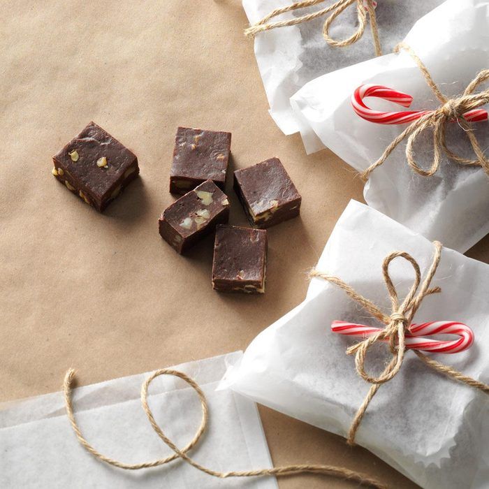 four pieces of chocolate tied with twine and candy canes on top of brown paper