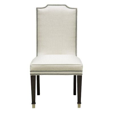 a white upholstered chair with black legs and nail polishing on the back