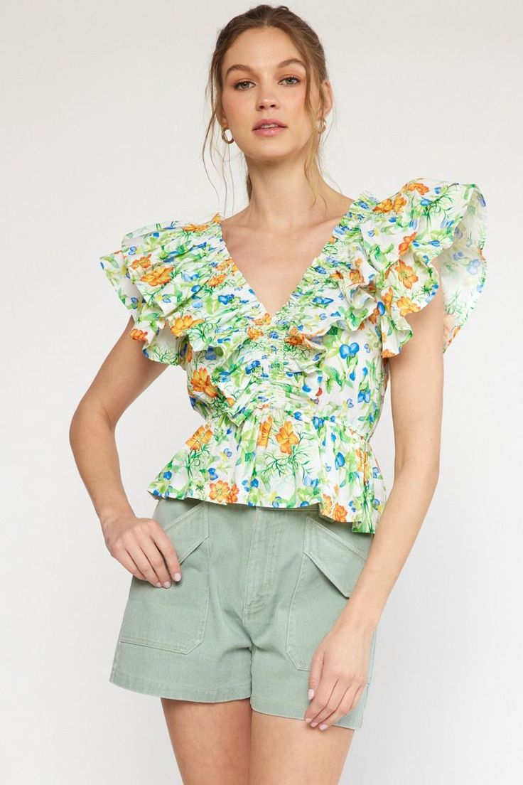 Get ready to turn heads with our Ruffles All Around Top! This playful top features a v-neck and cinched waist, creating a flattering silhouette. With a gorgeous floral print in vibrant greens, blues, orange, and yellow, you'll stand out in any crowd. (Seriously, you'll be the talk of the town.) Don't miss out on this unique piece! True to size. If in between sizes, size up. I’m in the medium here but can also wear the small. Sizes: Small-Large Follow tag instructions for washing and ironing. Green V-neck Top With Ruffles, Green Floral Print Tops For Day Out, Spring Green Tops With Floral Print, Vibrant Print V-neck Top For Brunch, Green V-neck Top With Vibrant Print, Green Floral Print Top For Brunch, Green Floral Print Blouse For Brunch, Printed Green Tops For Brunch, Green V-neck Top For Brunch