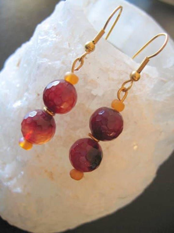 Lovely Drop earrings with TWO FACETED Ruby Glass Beads....Shaded glass handmade so there are slight variations in each glass bead...Small Yellow glass beads separate the Red ones giving length and separation... I have threaded them all onto Gold fittings.. Non-Allergenic.... Measure from base of Hook to end 3.5+Cms Elegant look ! Glass Earrings With Faceted Beads As A Gift, Glass Faceted Beads Earrings For Gift, Glass Earrings With Faceted Beads For Gift, Handmade Amber Round Bead Earrings, Handmade Amber Beaded Round Earrings, Handmade Amber Earrings With Round Beads, Spiritual Czech Glass Earrings For Jewelry Making, Glass Beaded Earrings With Dangling Beads For Gift, Amber Czech Glass Earrings With Ear Wire