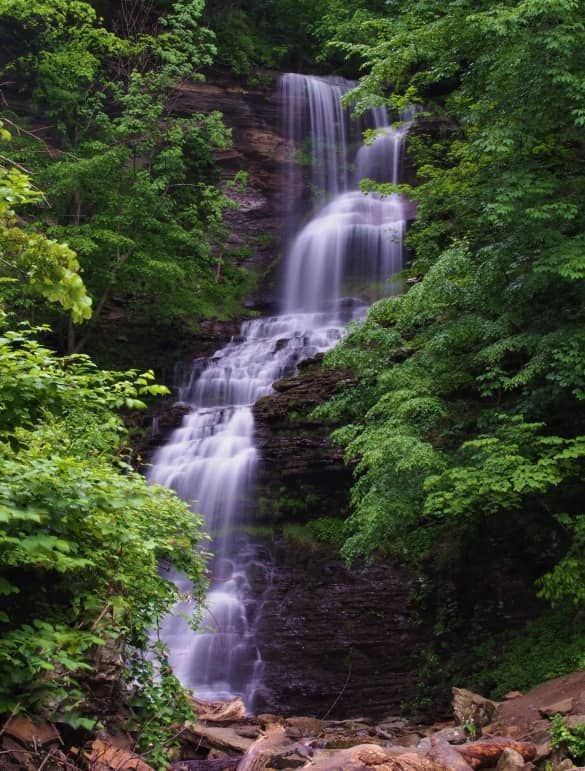 a large waterfall surrounded by lush green trees