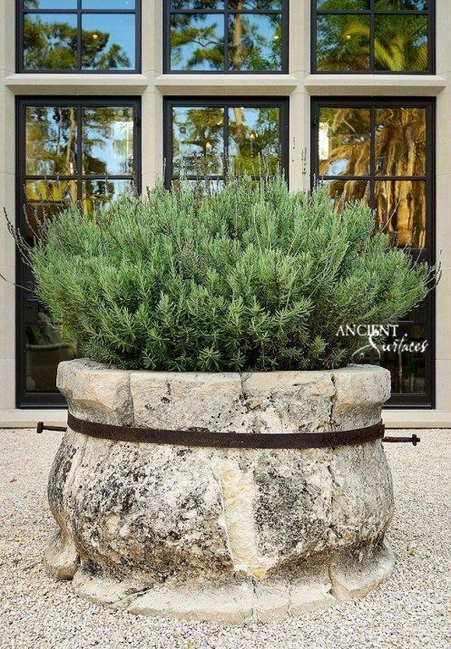 a stone planter sitting in front of a window