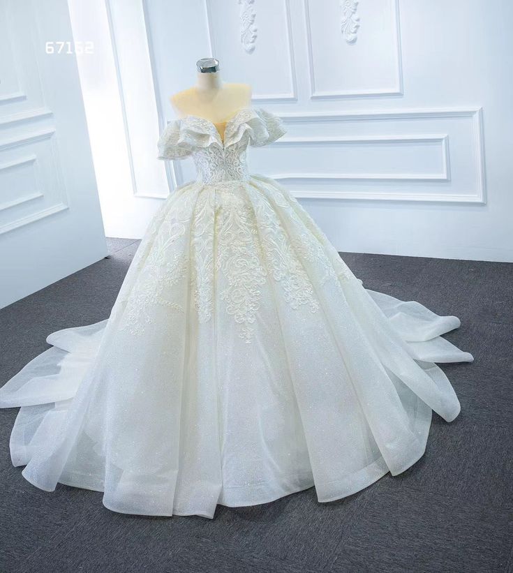 a white wedding dress on display in a room