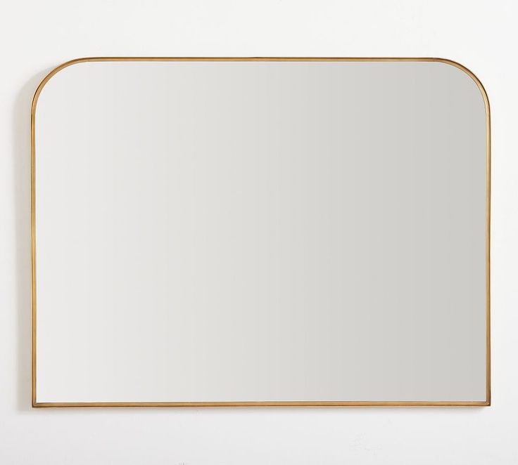 a square mirror on the wall with a gold frame around it and a white background