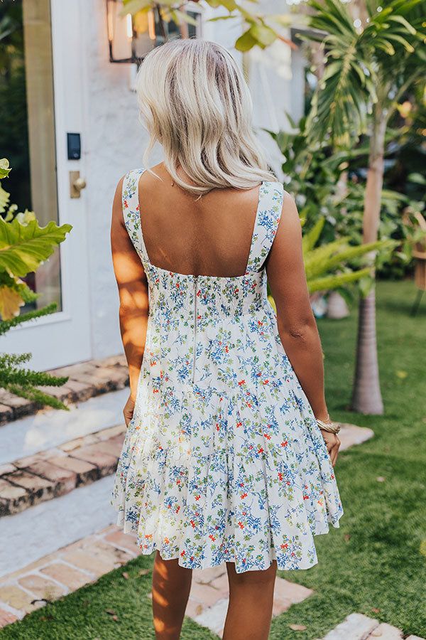 - This sweet dress is perfect for a stylish look! - Fully lined material with a colorful floral print - A v-cut neckline - Wide straps - A bodice with a front tie feature, a cut-out detail, a smocked back, and back zip closure - A flowy yet flattering silhouette that ends in a rounded hemline with ruffle detail White V-neck Dress For Picnic, Summer Floral Dress With Square Neck For Day Out, Vacation Floral Print Sundress With Square Neck, Summer V-neck Sundress With Ditsy Floral Print, Vacation Floral Print Square Neck Sundress, Floral Print Square Neck Sundress For Vacation, Summer Floral Print Square Neck Sundress, Summer Sundress With Floral Print And Square Neck, Floral Print Square Neck Mini Dress For Vacation