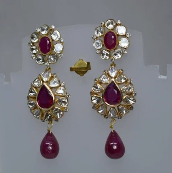 Ruby Gemstone, Uncut Polki Diamond Earring, Wedding Earring, 925 Sterling Silver, Gold Plated, Polki Earring, Ruby Earring, Polki Jewelry. Manufacture Country : India * Customization always available for Ring size, metal selection and any type of center stones changes, etc.... * If you want to make your own idea of Jewelry we can do it. Material : 925 Sterling Silver Main Stone : Ruby Secondary Gemstone : Polki, Pave Diamond Gemstone Color :   Gemstone Shape : As Seen In A Picture Weight : 29.65 gm * Shipment will dispatch within maximum 2-3 Days of Order done * Some Special customization can take more Time * UPS, DHL, FEDEX OR ARAMEX Will be available for Delivery Exquisite Ruby Earrings In White Gold, Pear-shaped Fine Jewelry Earrings For Wedding, Exquisite White Gold Ruby Earrings, Wedding Gemstone Drop Chandelier Earrings, Wedding Chandelier Drop Earrings With Gemstones, Fusion Style Gemstone Chandelier Earrings For Wedding, Elegant Ruby Diamond Earrings For Wedding, Pear-shaped Ruby Gemstone Earrings, Wedding Drop Earrings With 17 Jewels