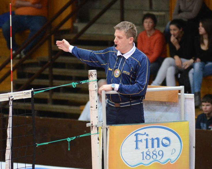 a man standing next to a net on top of a tennis court in front of a crowd