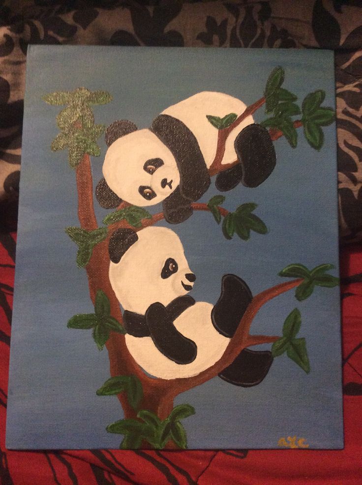 two panda bears sitting on top of a tree