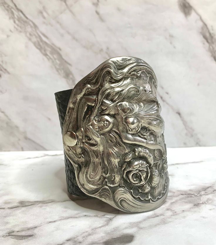 "Amazing vintage Art Nouveau 'Maiden With Rose' quadruple silver-plated cuff bracelet, dating to the early 1900's. This stunning, piece of antique silver depicts a beautiful, full-figural rendering of a woman with flowing hair and sensuous gown.  The cuff  features ornate raised repouse' details typical of the Nouveau period: sinuous scrolls, flowers, flowing lines.  The detail is spectacular. The silver is in lovely vintage condition, with beautiful patina.  It is securely mounted onto a very s Silver Hand Cast Metal Cuff Bracelet, Silver Metal Cuff Bracelet Hand Cast, Vintage Hand Cast Bangle Cuff Bracelet, Vintage Hand Cast Cuff Bangle, Vintage Hand Cast Cuff Bangle Bracelet, Antique Silver Cuff Bracelet As Gift, Victorian Adjustable Engraved Cuff Bracelet, Vintage Hand Cast Cuff Bracelet As Gift, Adjustable Antique Silver Cuff Bracelet With Unique Style