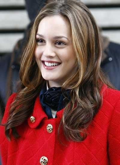 a woman in a red coat smiles at the camera