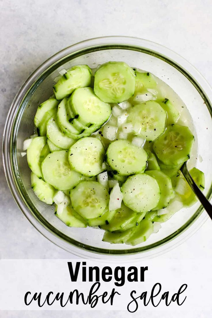 a glass bowl filled with cucumber slices on top of a white countertop