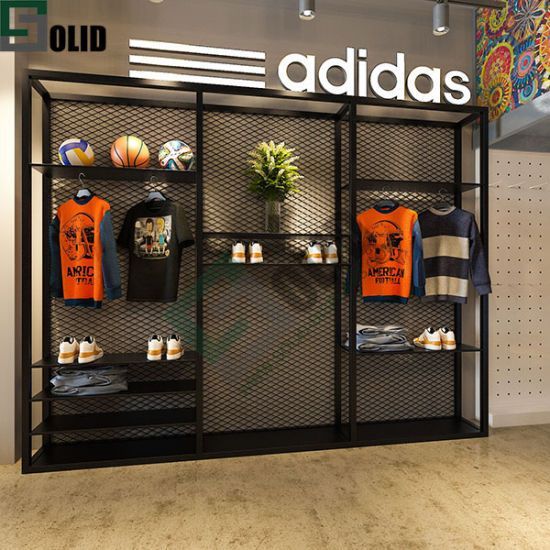 an adidas store display with orange shirts and basketballs on the shelves in front of it