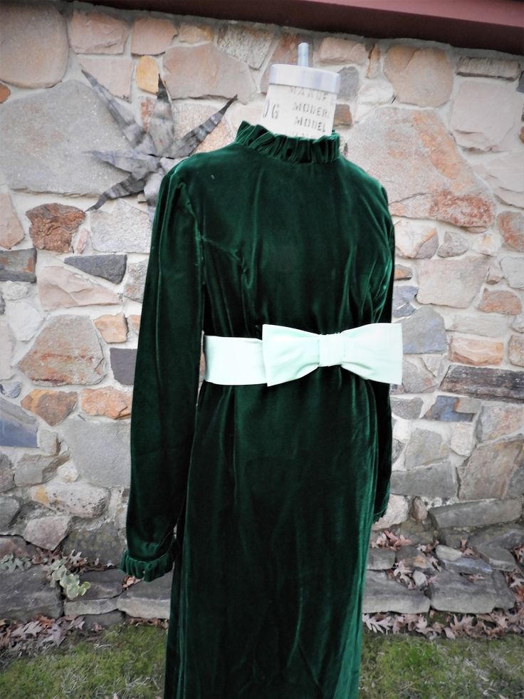 "BEAUTIFUL Vtg 1970's Green Velvet Maxi Misses Formal Full Length Dress with Mint Green Sash and Bow sz XS This is a lovely vintage 1970's full length maxi dress. There is paper tag here which says size 6 however by todays standards it is a Misses size being very petite. The dress is comprised of a lovely deep green velvet. The high neckline and cuffs of the sleeves are embellished with a rushed trim which is lovely. There is a large sash in a mint green satin with a large bow at the front. Ther Green Vintage Winter Dress, Vintage Green Winter Dresses, Green Vintage Dress For Fall, Retro Long Sleeve Costume Dress, Retro Dresses For Vintage Events In Fall, Retro Fall Dresses For Vintage Events, Retro Long Sleeve Vintage Costume Dress, Retro Long Sleeve Vintage Dress For Costume, Vintage Winter Costume Dresses