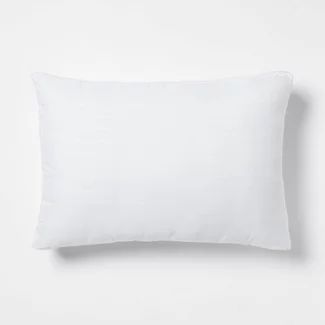 a white pillow on a white wall with an empty space for the text or image