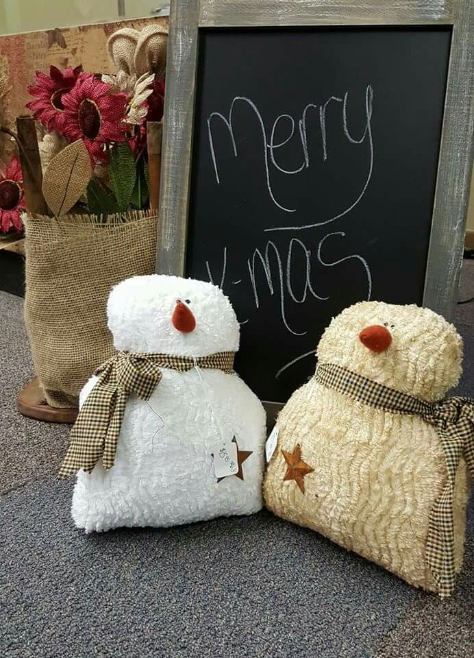 two snowmen sitting next to each other in front of a blackboard with merry christmas written on it