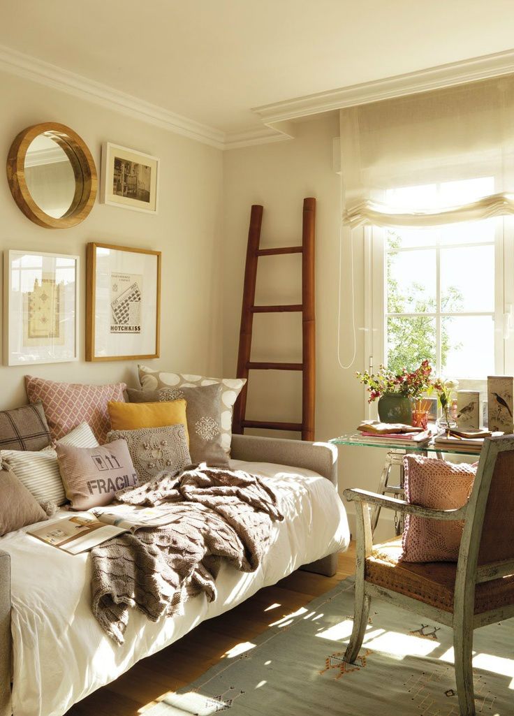 a living room filled with furniture and pictures on the wall next to a ladder in front of a window