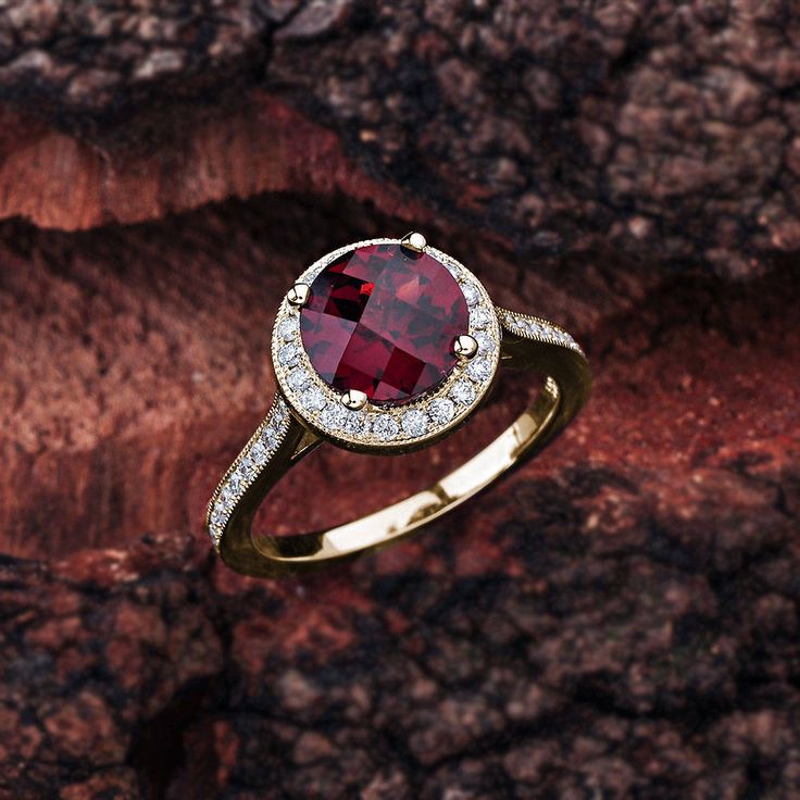 This garnet engagement ring in 14K white gold features a round garnet center stone that is complemented by brilliant white, sparkly diamond side stones. Garnet Engagement Details: 100% Handmade in the USA Center Stone - Garnet (2.00 carat AAA / VS) Metal - 100% Solid 14K (In Rose, Yellow, or White) Diamond Side Stones: Carat Weight - 0.33 carat total weight Shape - Round Cut Diamonds Color - G - H Clarity - SI1 Finger Size: We can make this setting in any finger size you need! Contact us if you Luxury Round Ruby Ring With Diamond Accents, Luxury Ruby Ring With Diamond Accents And Round Shape, Luxury Round Ruby Ring With Halo Design, Classic Round Ruby Ring With Halo Design, Fine Jewelry Round Cluster Ring With Garnet, Fine Jewelry Garnet Cluster Ring, Lab-created Ruby Birthstone Ring With Center Stone, Classic Ruby Birthstone Ring With Halo Setting, Classic Ruby Ring With Brilliant Cut Garnet