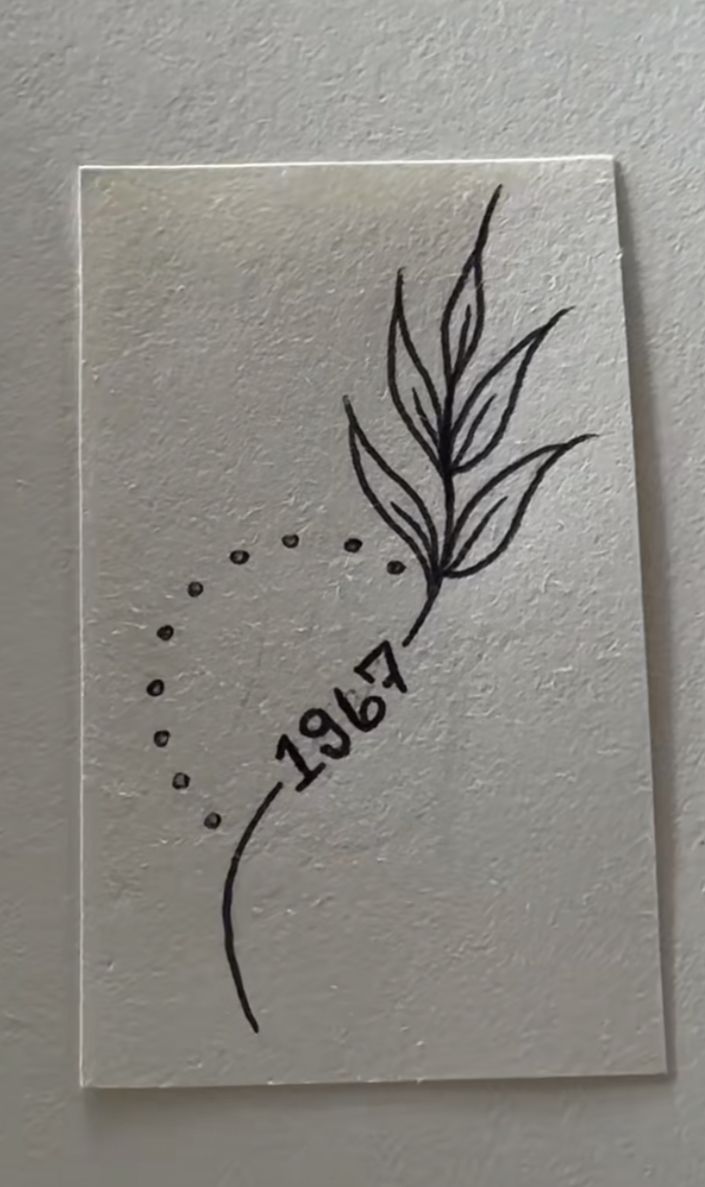 a piece of paper with the word love written on it and a drawing of a leaf