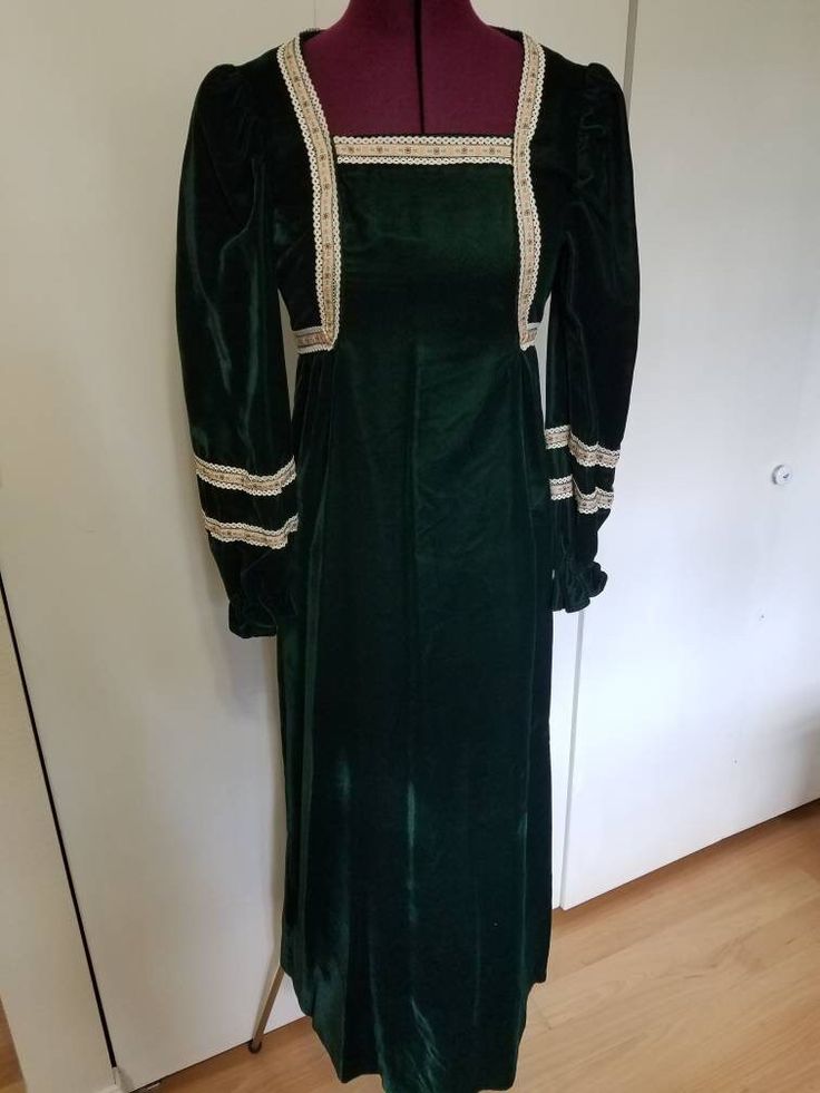 "Amazing handmade dress from the 70's! Maxi length and long sleeve. Emerald green velvet. Floral ribbon and lace throughout. Zipper in the back. Elastic on sleeve cuffs. In Excellent Vintage Conditon with some small marks to the velvet.  Estimated size XS. Measurements: Bust: 32\" Waist: 27\" Hips: 32\" Length: 54\" Shoulders: 14.5\" Sleeve Length: 24\"" Green Long-sleeved Velvet Dress, Vintage Green Winter Dresses, Green Vintage Winter Dress, Green Long Sleeve Vintage Dress For Party, Green Long Sleeve Vintage Party Dress, Vintage Long Sleeve Dress For Costume Party, Retro Long Sleeve Costume Dress, Formal Long Sleeve Vintage Dress, Formal Long Sleeve Vintage Dress With Lace Trim