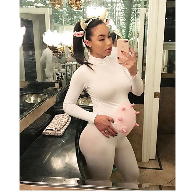 a woman taking a selfie in front of a mirror with a piggy bank