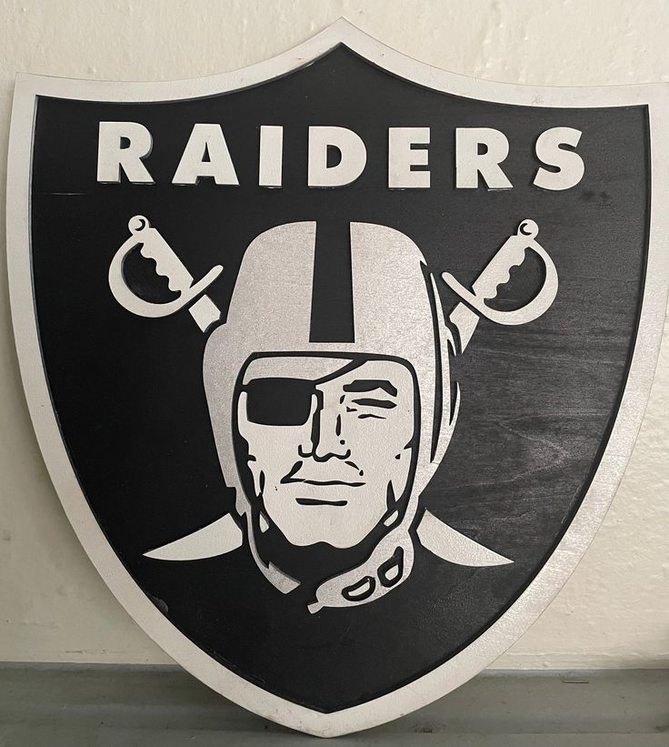 a black and white sign with a helmet on it that says oakland football, raiders