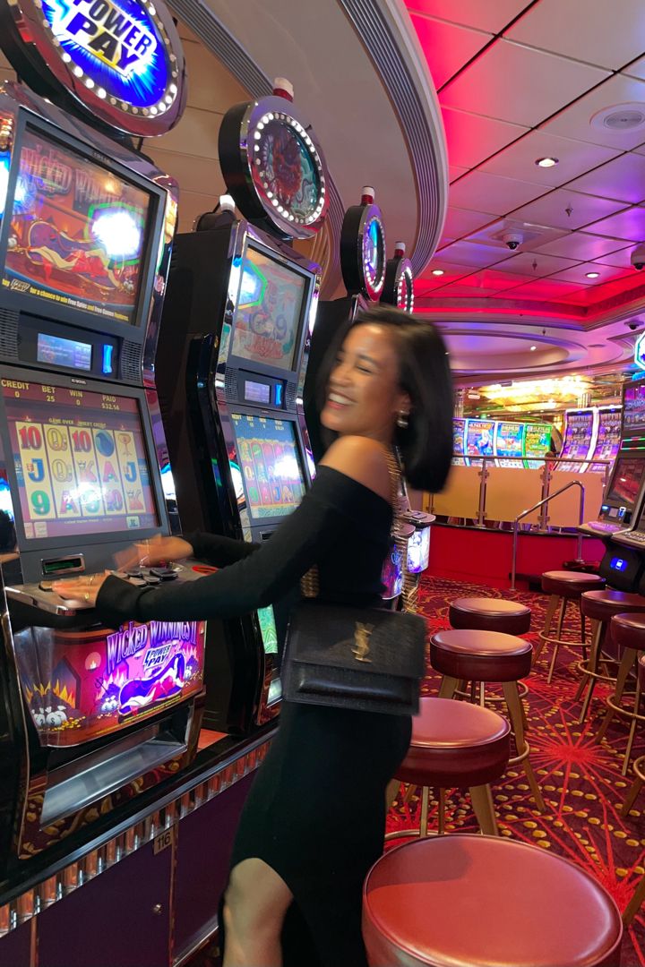 a woman standing next to slot machines in a casino