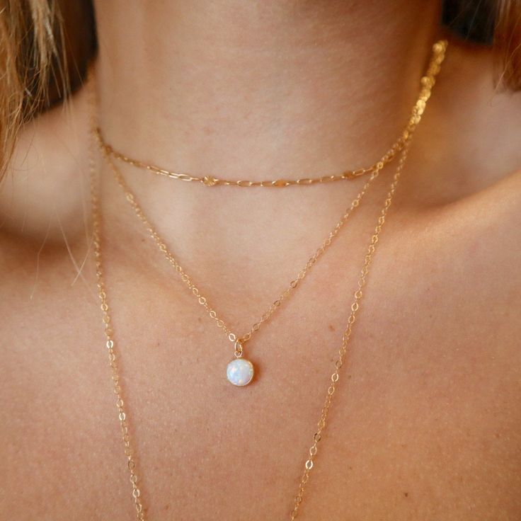 Our handmade necklace featuring a lovely round white opal pendant is a true gem, crafted with Gold Filled materials. Opal has long been regarded as a stone of good fortune, and this pendant is no exception! It's the perfect accessory for any occasion, adding a touch of classic beauty to her style. Our opal necklace is simply delightful, the perfect gift to enhance her daily look! DETAILS: 14kt Gold Fill Gemstone: White Opal Gemstone Shape: Round Gemstone Size: 6 mm ~HANDMADE WITH LOVE ~ WATERPRO Opal Clavicle Chain Jewelry Gift, Gold Opal Jewelry With Round Stone, Fine Jewelry Opal Round Necklaces, Delicate Opal Chain Jewelry Gift, Delicate Opal Chain Jewelry As Gift, Opal Jewelry With Delicate Chain As Gift, Delicate Opal Chain Jewelry For Gifts, Delicate Gold Opal Jewelry, Delicate Opal Jewelry With Birthstone