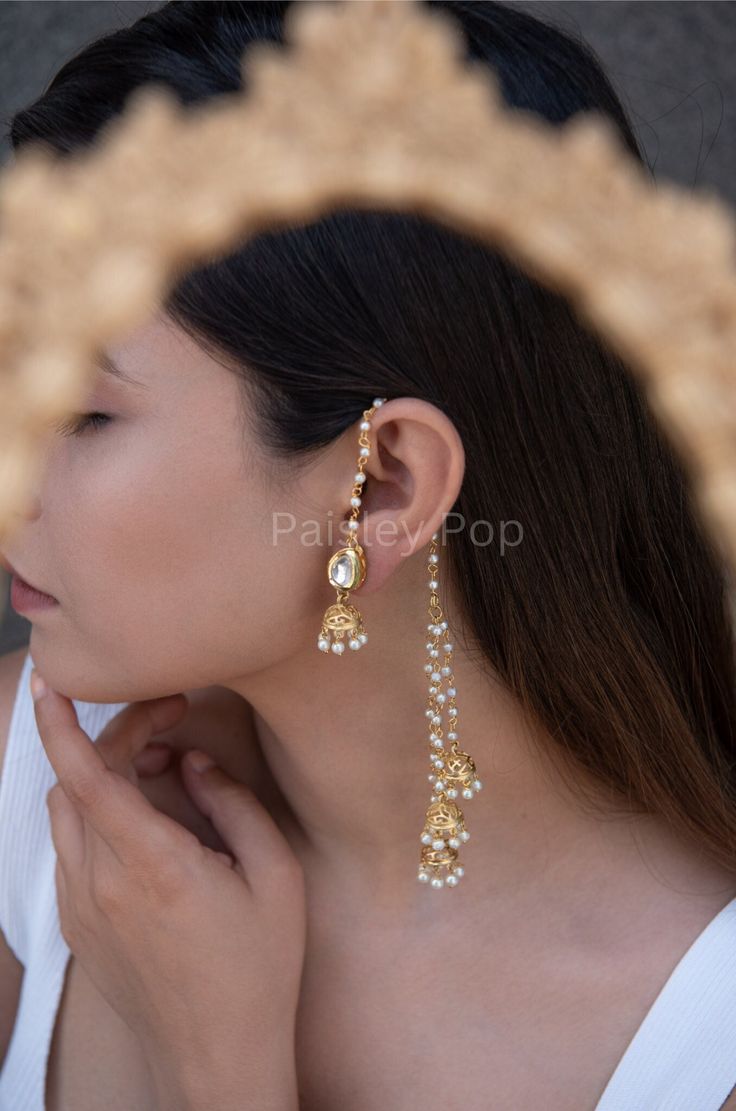 The gold-plated kundan jhumkis are traditionally inspired by the rich Indian Heritage of jewelry making. The design of the bridal jhumkis earrings features pearl hangings and a top encrusted with kundan. These ethnic jhumkis have a gold-plated pearl chain that gives them a delicate and elegant look. The richly traditional design is versatile and can be paired with almost anything Indian.  Closure - Push Back Handcrafted in Jammu and Kashmir  Paisley Pop travels the depths of India to learn techniques and crafts from deep down the local markets and villages. We give utmost importance to our quality and packaging. Our goal is to make sure you receive exactly what you are looking for and for your experience to be a special and memorable one. We are ready to help and advise you through your pu