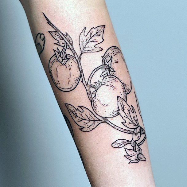 a tattoo on the arm of a woman with peaches and leaves growing from it