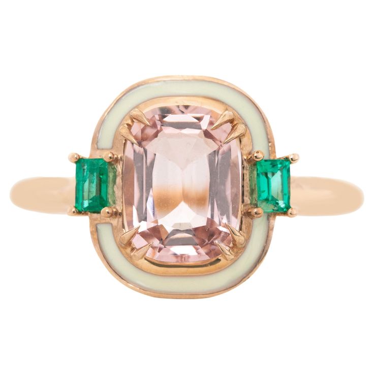 an antique pink and green tourmaline ring with two emerald stones in the center