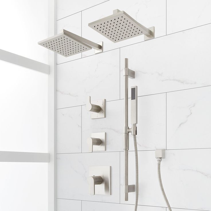 the shower head and hand shower faucet are shown in this white tiled bathroom