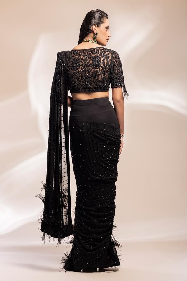 Black pre-draped saree with cutdana, beads and sequins hand embroidered lines. Comes with a padded blouse.
Components: 2
Pattern: Hand embroidered
Type Of Work: Cutdana, Beads, Sequins
Neckline: Deep V Neck
Sleeve Type: Half
Fabric: Saree: Silk georgette, Blouse: Tulle
Color: Black
Other Details: 
Attached petticoat
Length:
Blouse: 14 inches
Saree: 42 inches
Model Height: 5ft 7inches, wearing size 10
Product Weight: 5 Kgs
Note: Belt worn by the model is not for sale.
Occasion: Sangeet - Aza Fash Semi-stitched Sequined Pre-draped Saree For Reception, Evening Saree Blouse Piece With Resham Embroidery, Evening Blouse Piece With Resham Embroidery For Navratri, Evening Blouse Piece With Resham Embroidery For Saree, Unstitched Blouse For Evening Navratri, Unstitched Blouse Traditional Wear For Navratri Evening, Evening Navratri Blouse Piece With Resham Embroidery, Evening Blouse With Resham Embroidery, Evening Traditional Wear With Unstitched Blouse For Navratri