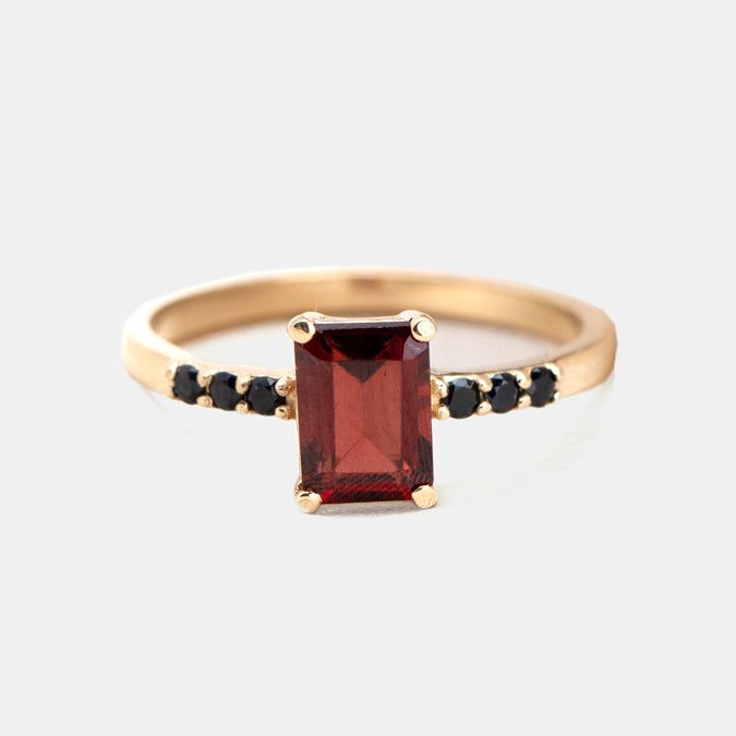 Beautifully stunning, this Deco-inspired ring features Garnet and black diamonds and is sure to turn heads. Classic Black Spinel Ring, Classic Black Spinel Promise Ring, Black Spinel Sapphire Ring For Anniversary, Formal Fine Jewelry Black Spinel Ring, Black Spinel Rings For Formal Occasions, Fine Jewelry Black Spinel Sapphire Ring For Anniversary, Formal Black Spinel Ring In Fine Jewelry Style, Fine Jewelry Sapphire Ring With Black Spinel For Anniversary, Elegant 14k Gold Rings With Black Diamonds