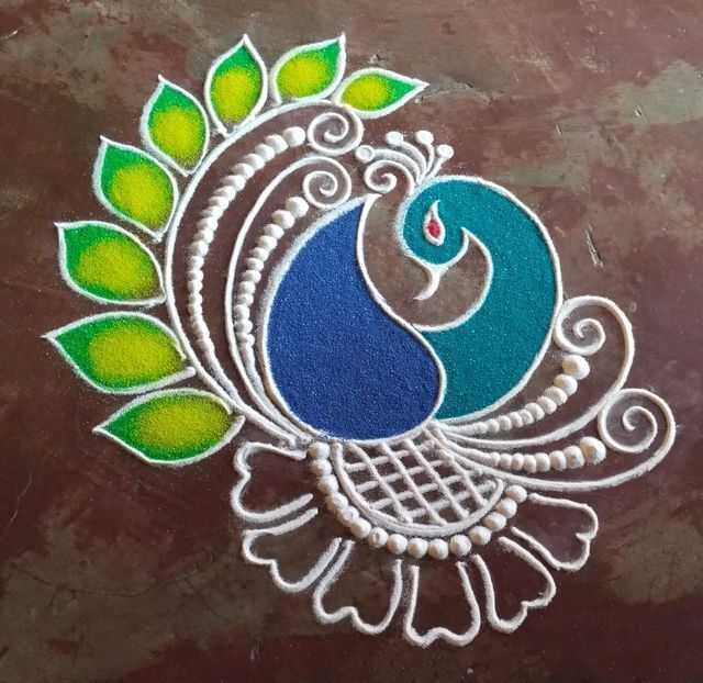 a peacock with green leaves on it's back and blue feathers painted on the side