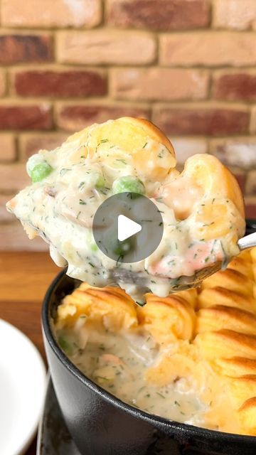 a spoonful of chicken pot pie being lifted out of a casserole dish