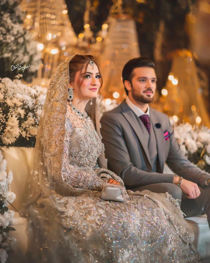 a bride and groom sitting on a couch