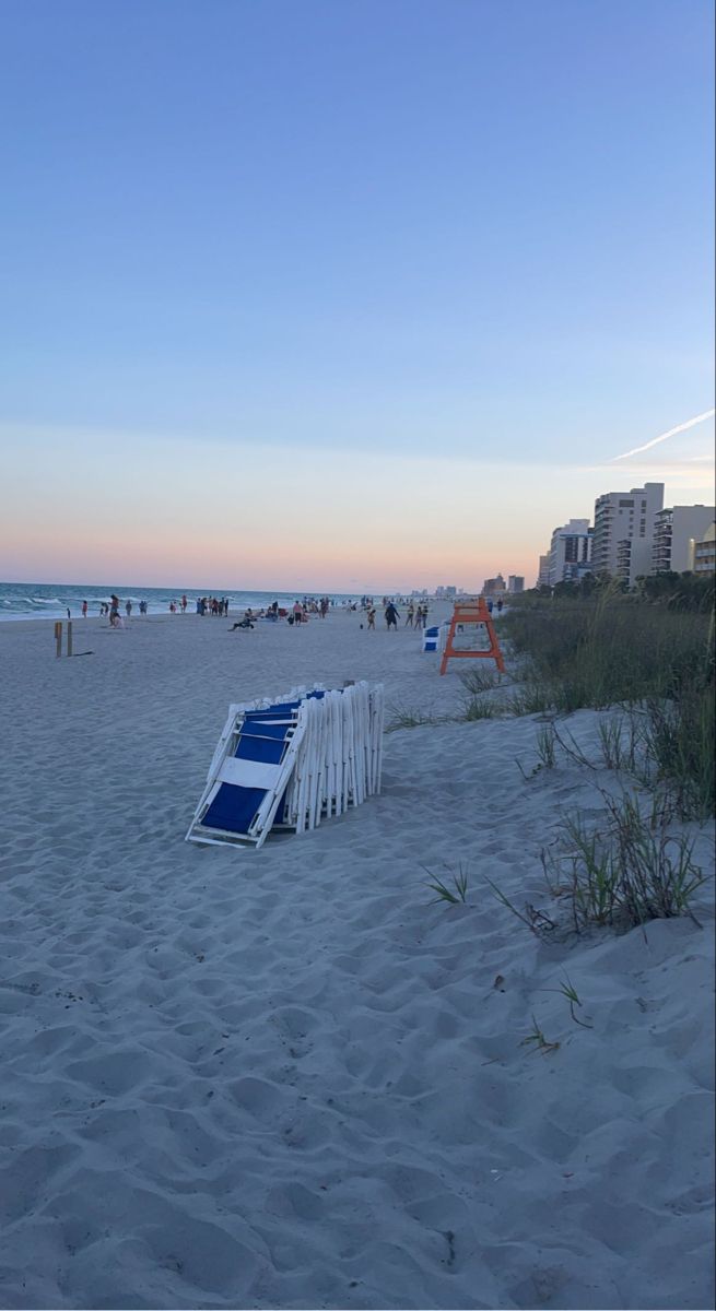 a beach with chairs and people in the background